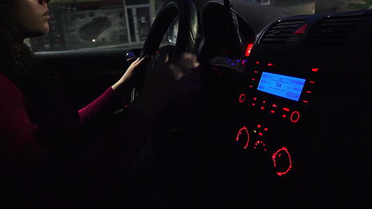 晚上开车——美丽的年轻女性晚上在城市开现代车视频的预览图