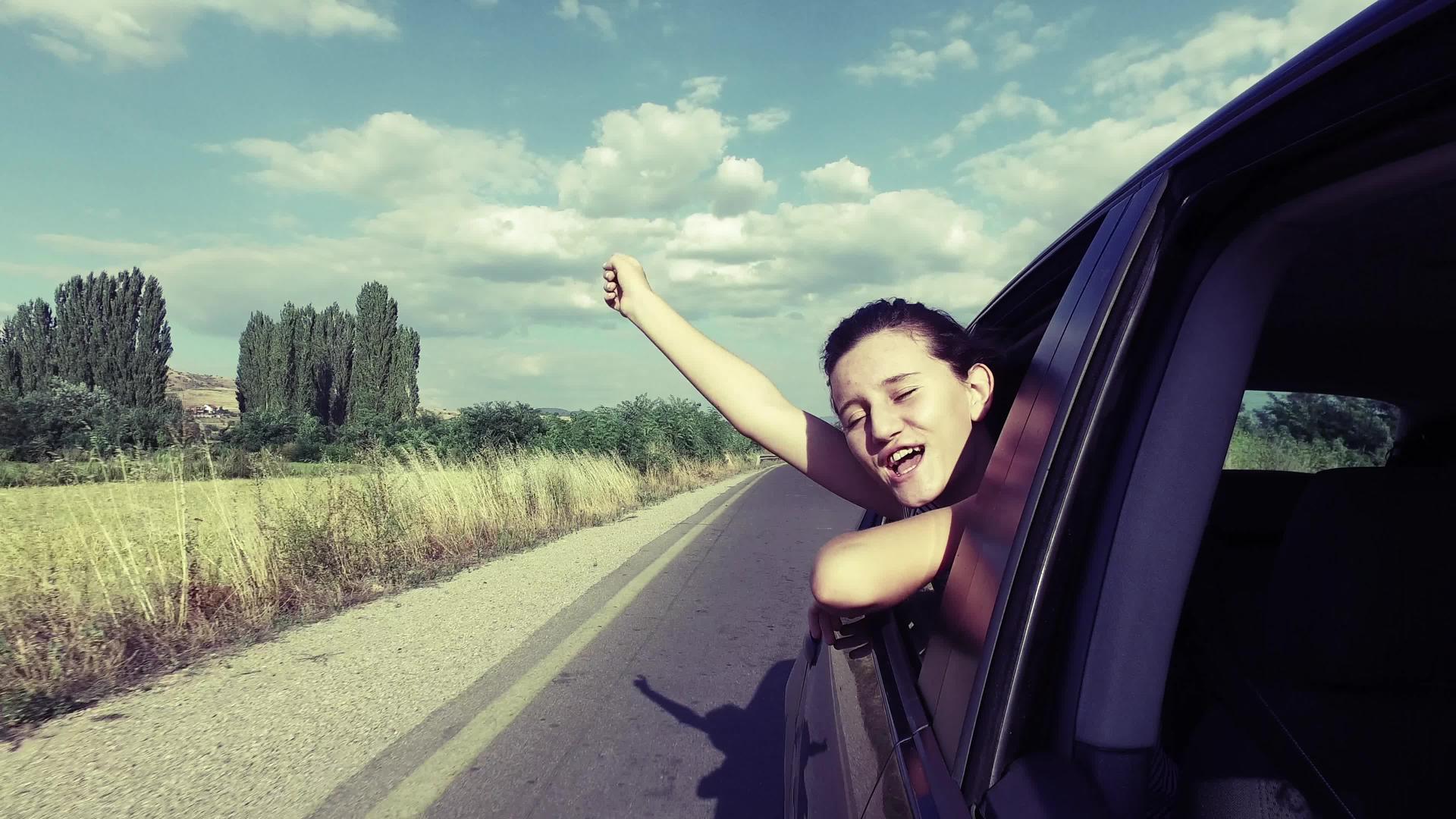 在路上旅行的女孩挥舞着舞蹈唱着歌在窗外微笑视频的预览图