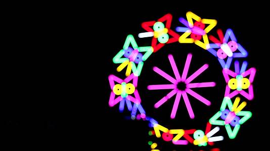 在夜市的晚宴上五颜六色的飞轮滚动着蝴蝶的荧光视频的预览图