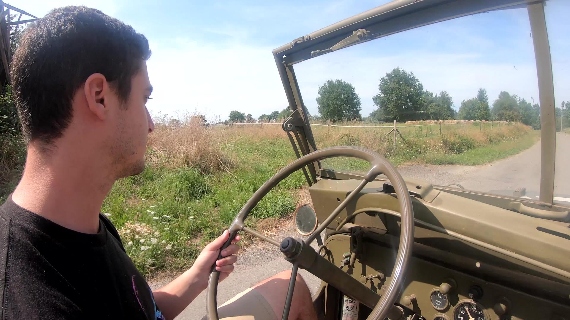 在土路上驾驶古代军用车的年轻人视频的预览图