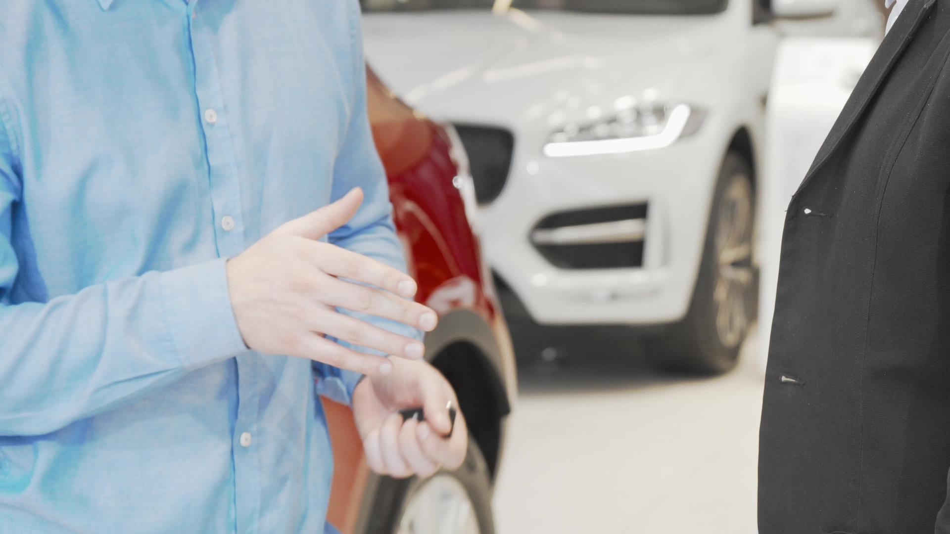 男人接受车钥匙和汽车经销商握手视频的预览图