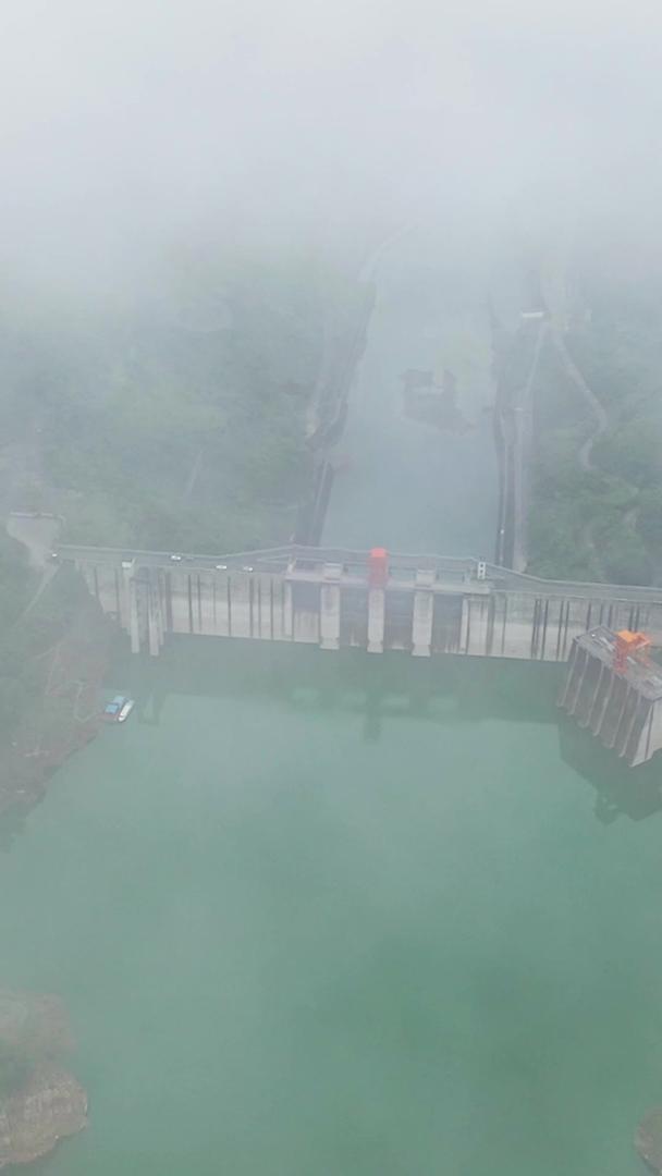 穿过云层俯瞰大坝的壮观景象航拍视频的预览图