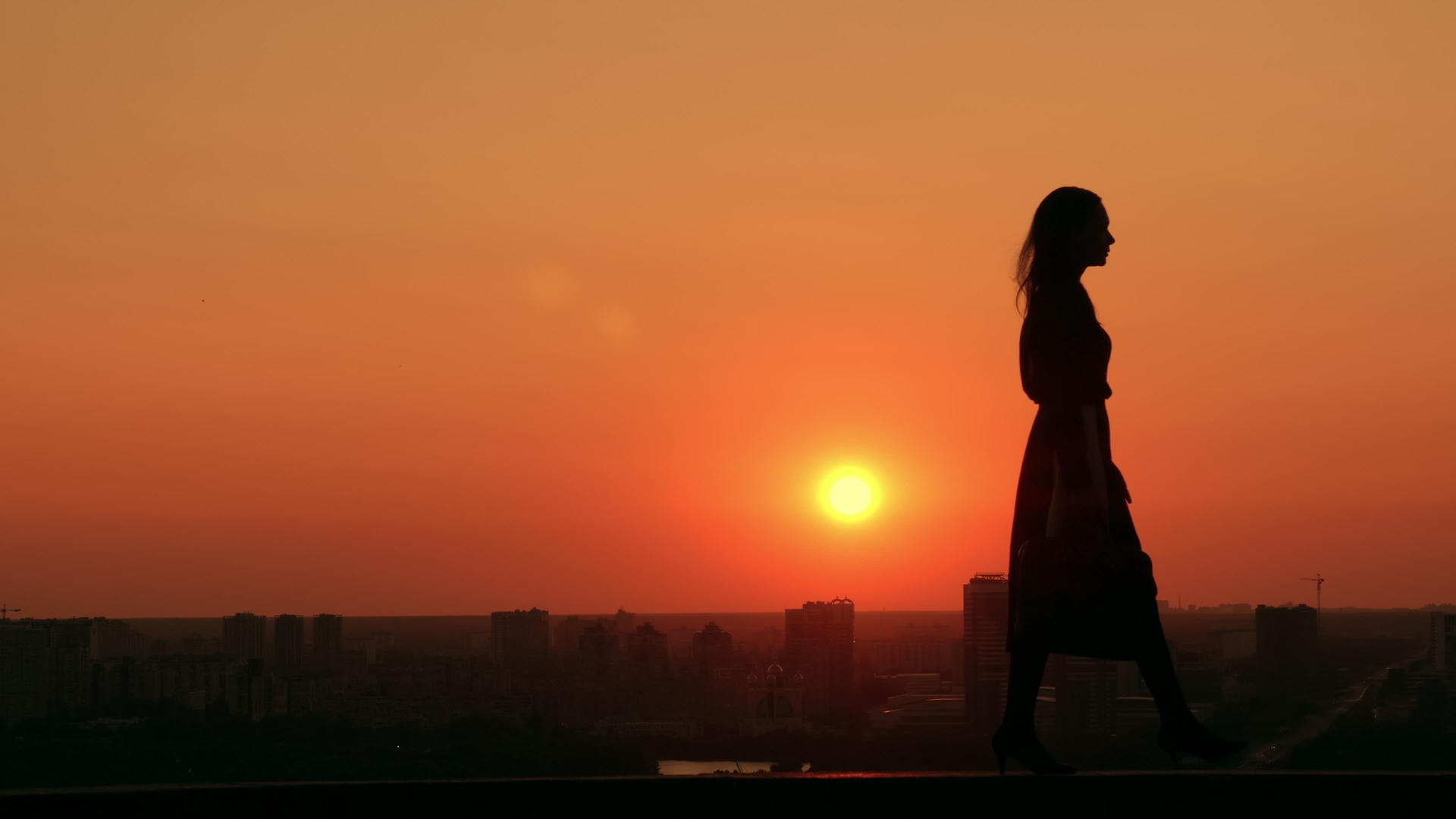 日出时城市中的女性走在城市的风景中视频的预览图