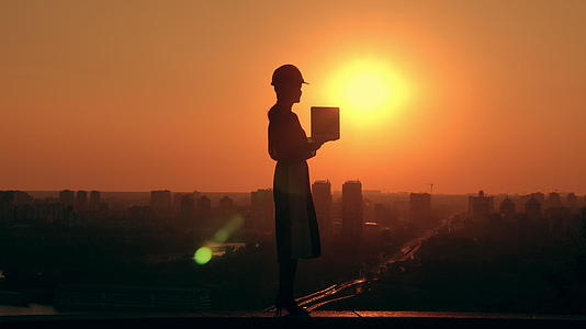 女工程师在日出时使用计算机户外城市景观视频的预览图
