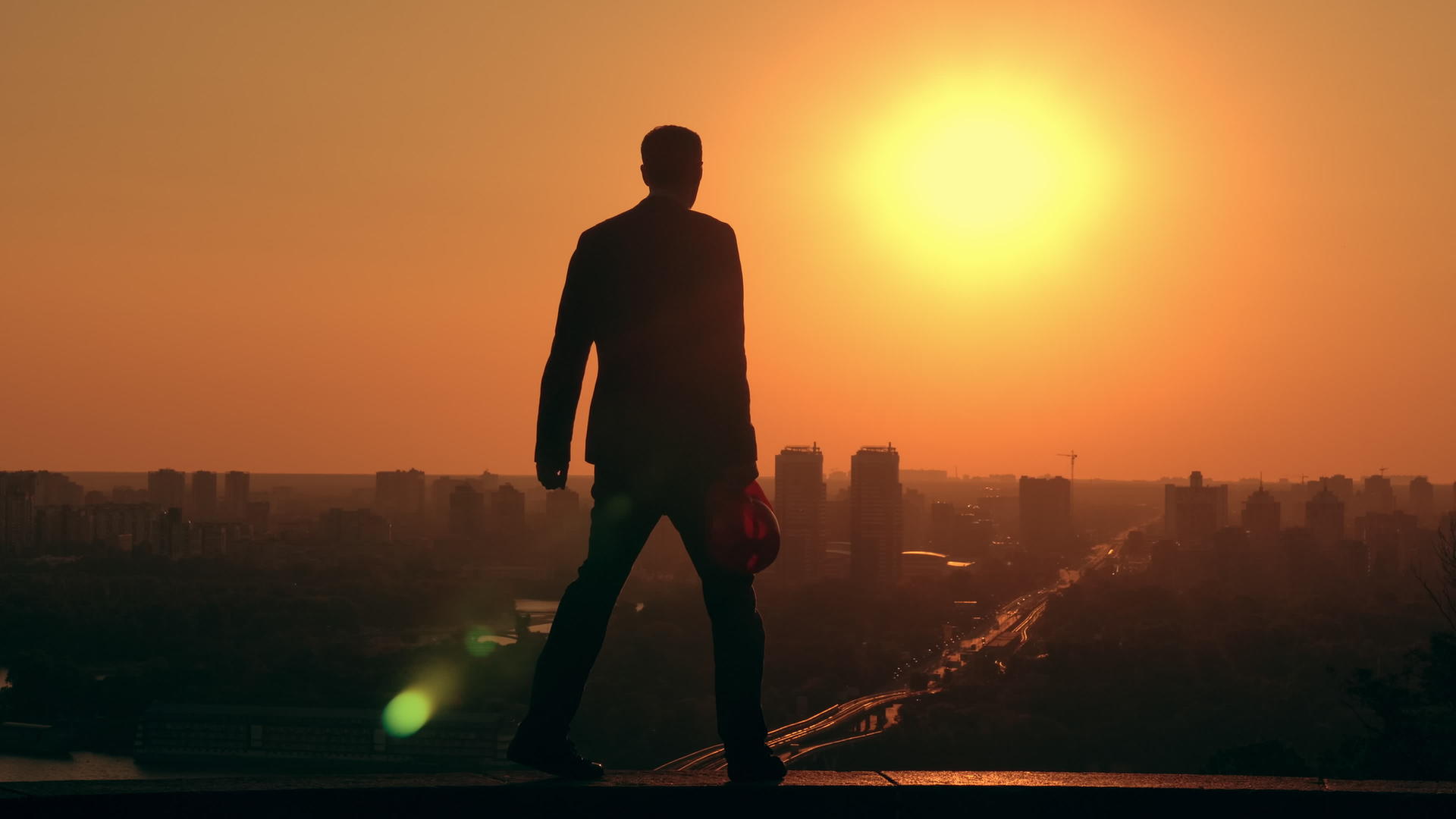 日出时戴头盔的男工程师在城市风景中行走视频的预览图