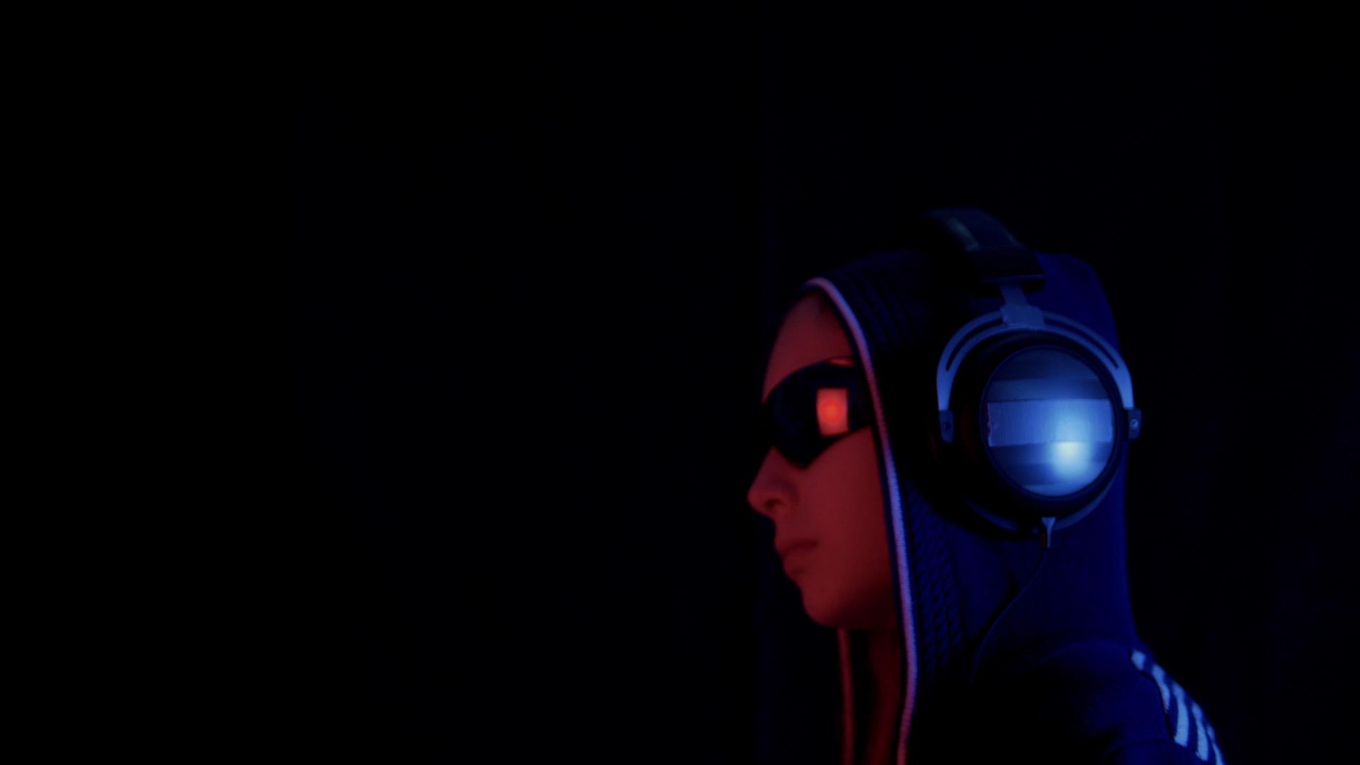 在黑暗中戴着连帽太阳镜和耳机的青少年视频的预览图