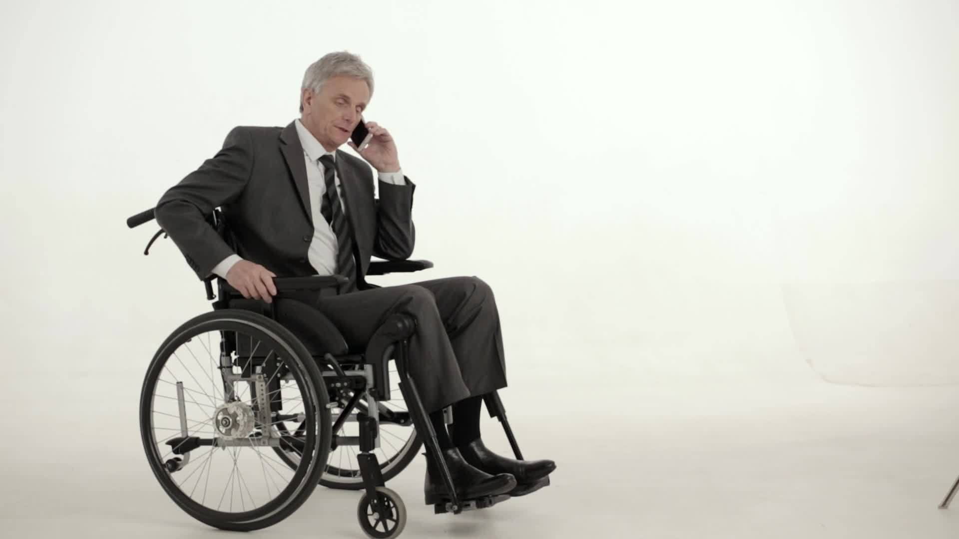 坐在轮椅上的瘫痪商人工作室拍摄视频的预览图