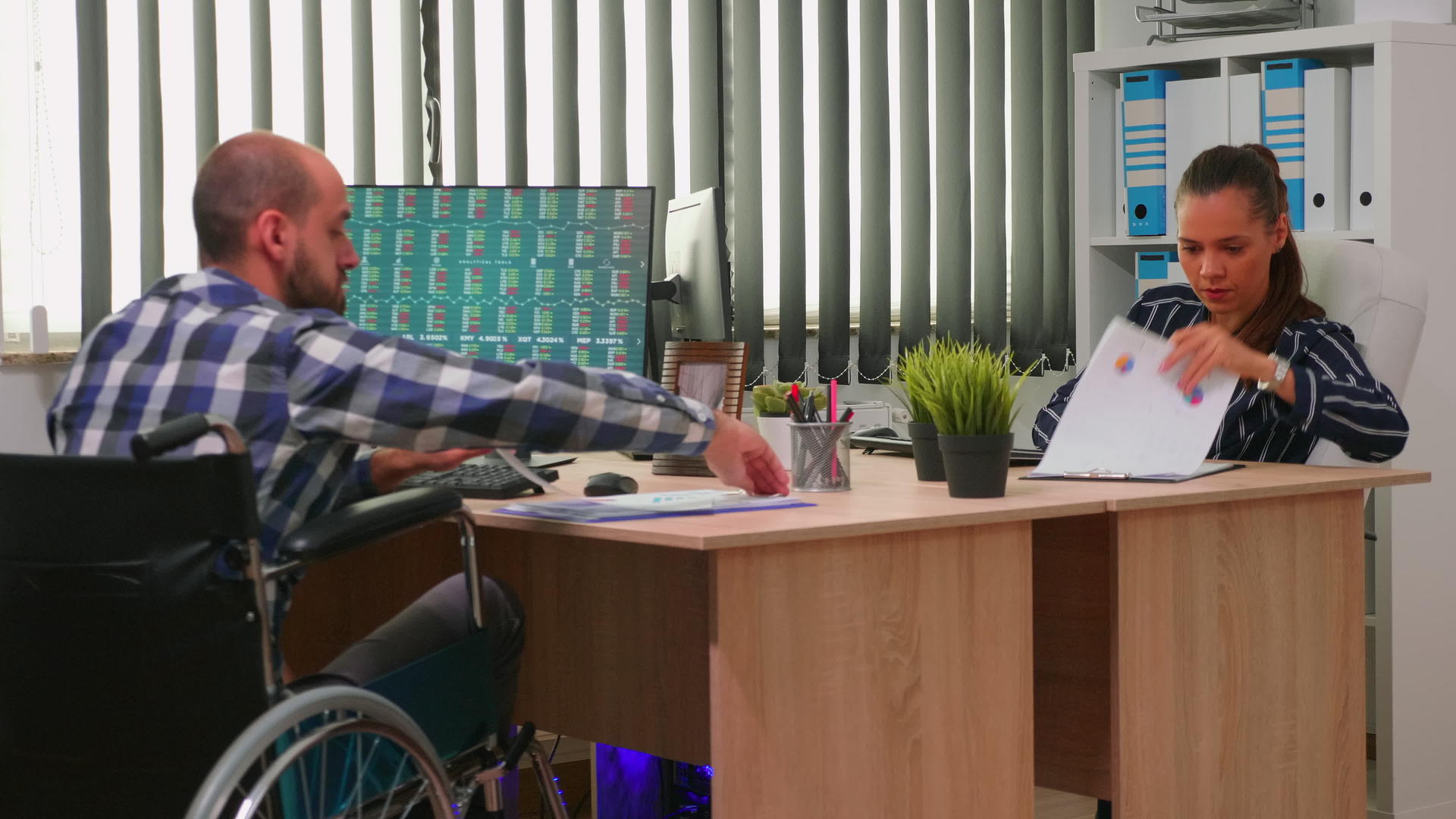 坐在轮椅上的商人在公司办公室工作视频的预览图
