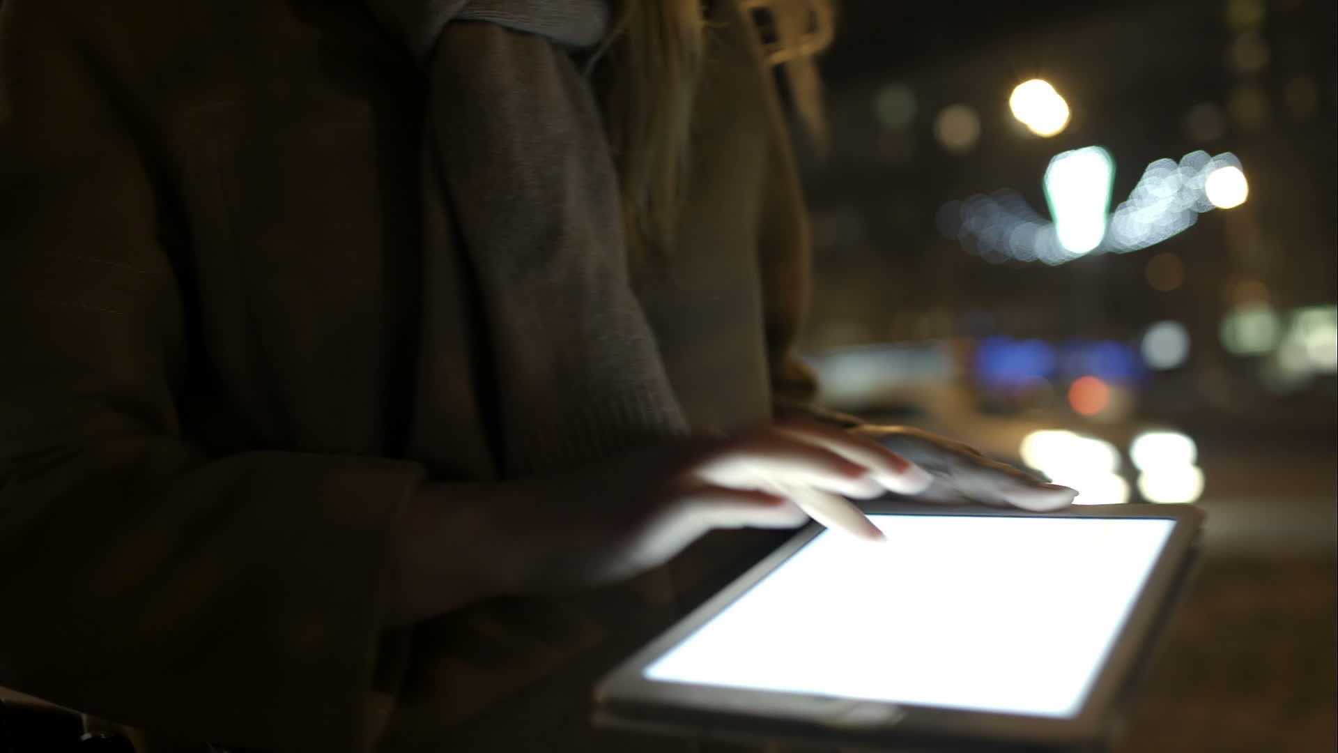 女人晚上走在街上用平板电脑视频的预览图