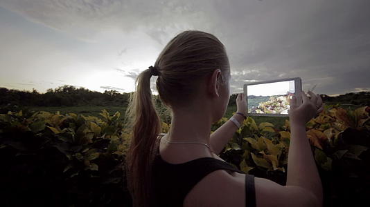 户外女性使用平板电脑制作自然场景照片视频的预览图