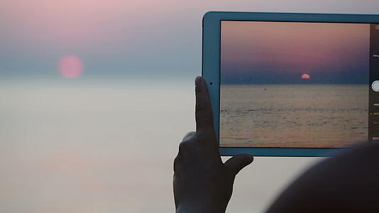 拍摄海边日落的照片和触摸垫视频的预览图