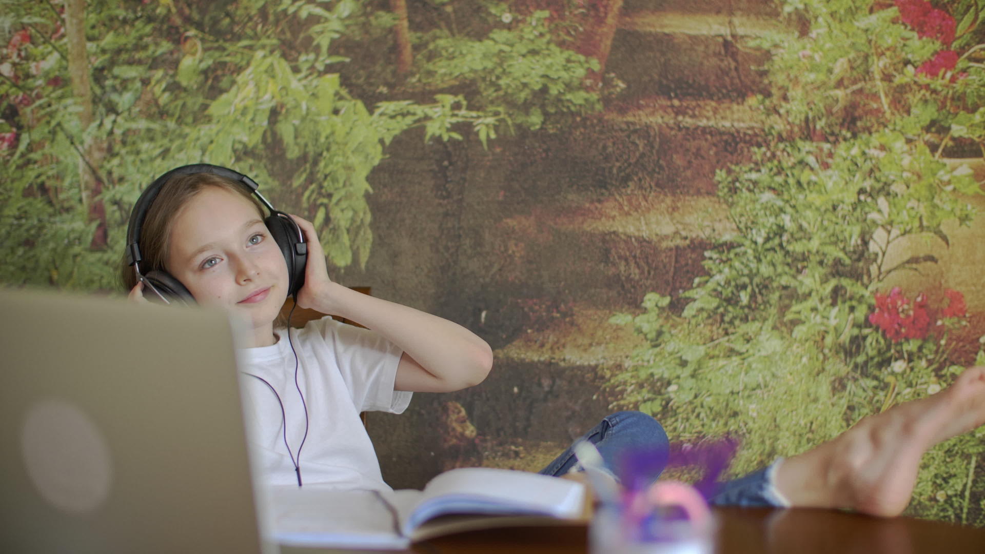 放松的年轻女孩有耳机坐在椅子上视频的预览图