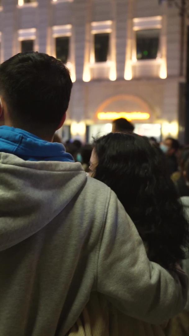 城市春季步行街夜晚相拥的情侣和拥挤的路人素材视频的预览图