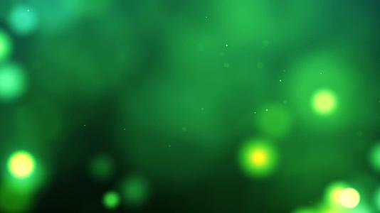 在绿色背景下小微粒子和明亮光线的循环运动突出了空间视频的预览图