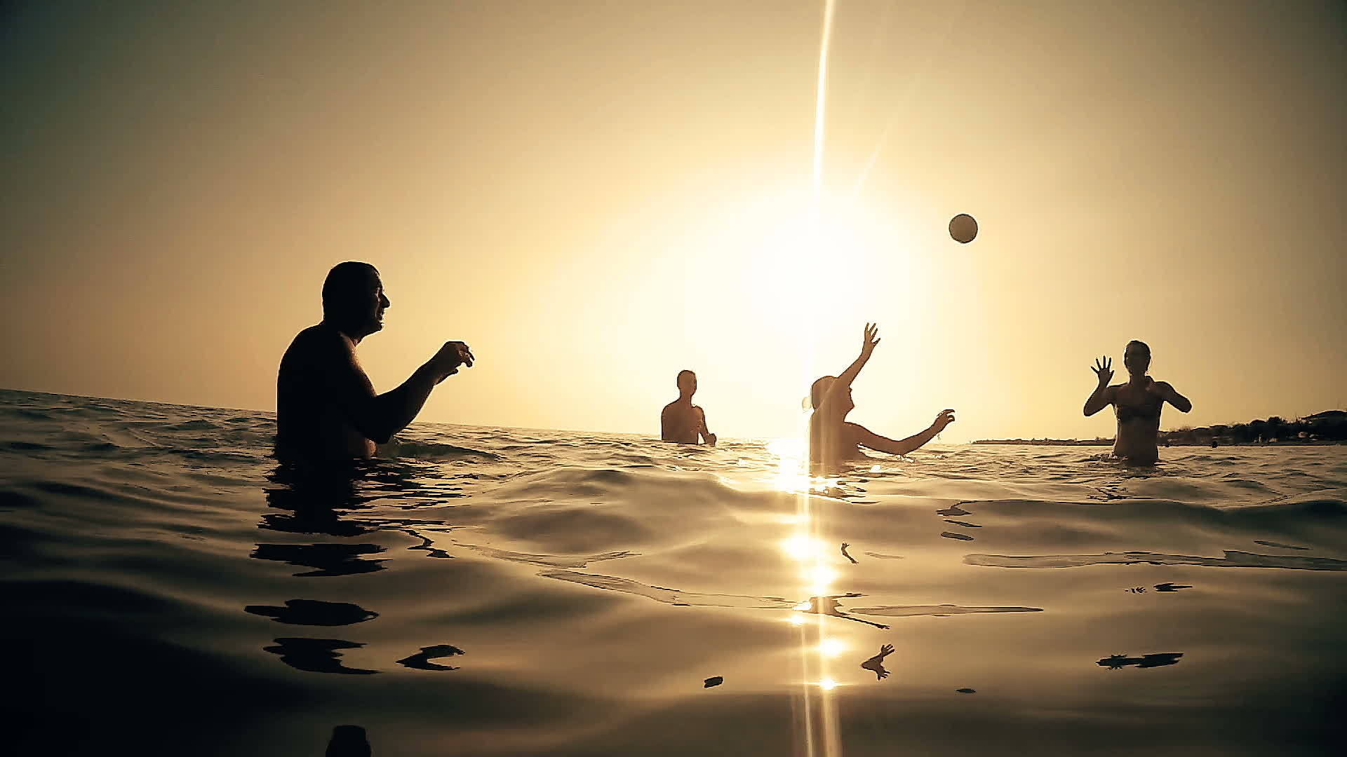 年轻人在日落时在海水中玩沙滩排球视频的预览图