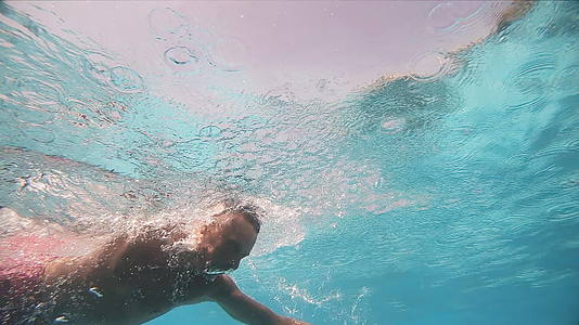 专业游泳运动员在室内游泳池游泳在水下慢慢爬行视频的预览图