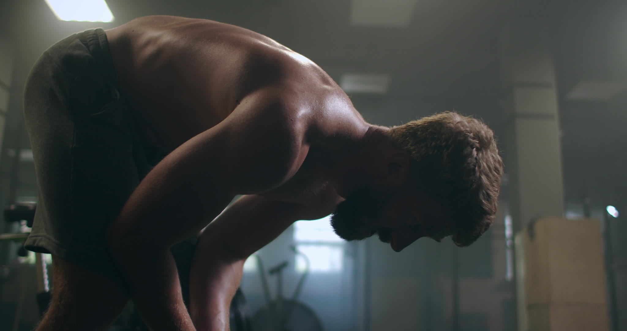 穿着运动服的年轻强壮的男人站在健身房的窗户前视频的预览图