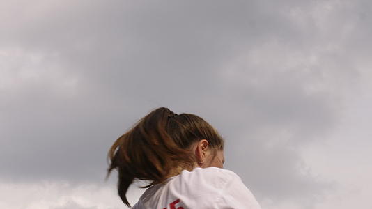 女运动员在多云的天空背景下举重、运动和体重鲍勃户外视频的预览图