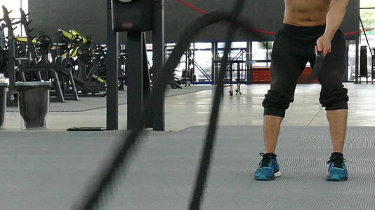 年轻人在健身中心锻炼男运动员在健身房用战绳训练运动型运动员视频的预览图