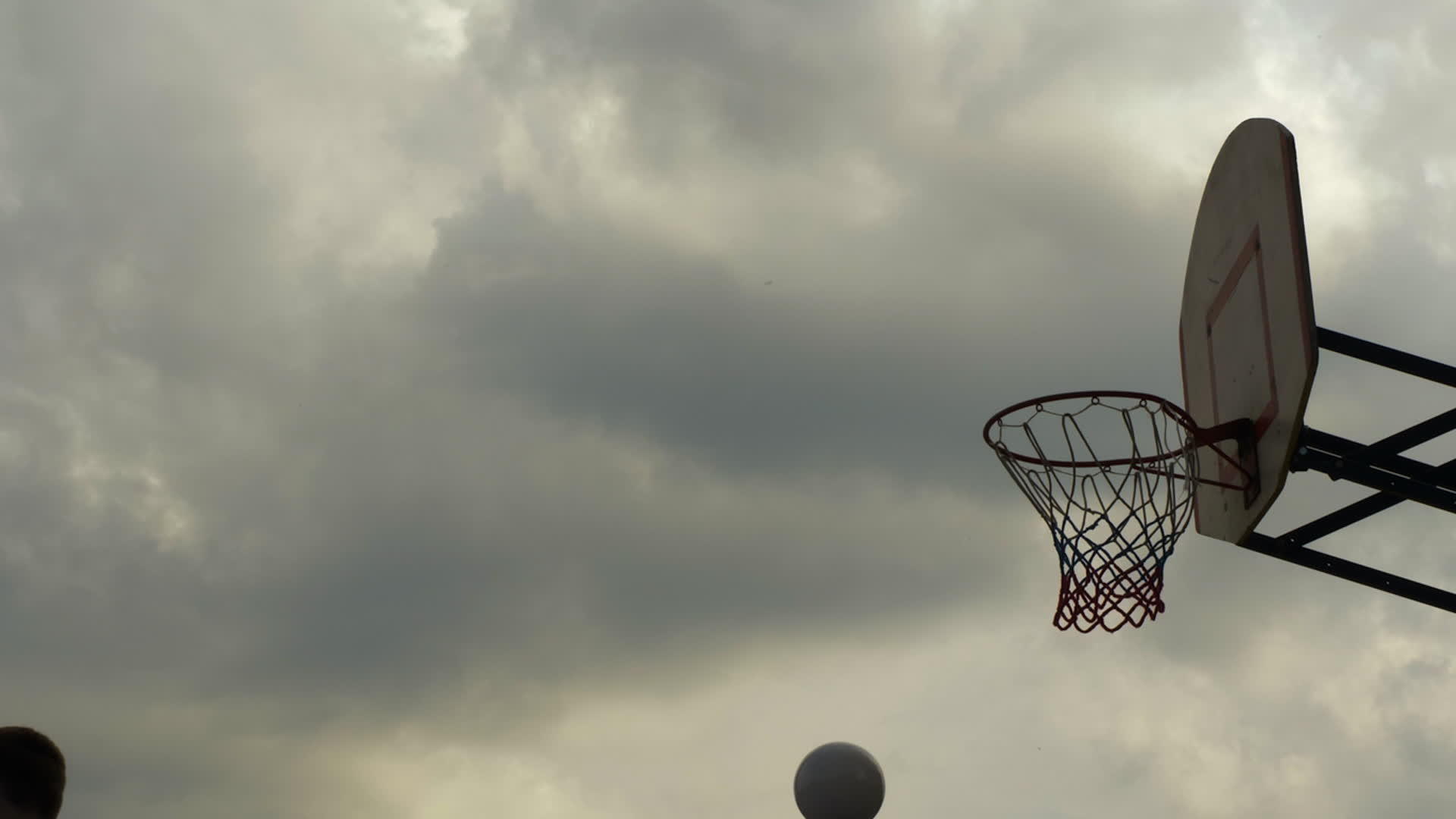 运动员把篮球扔进户外篮筐篮球运动员把它扔在运动场上视频的预览图