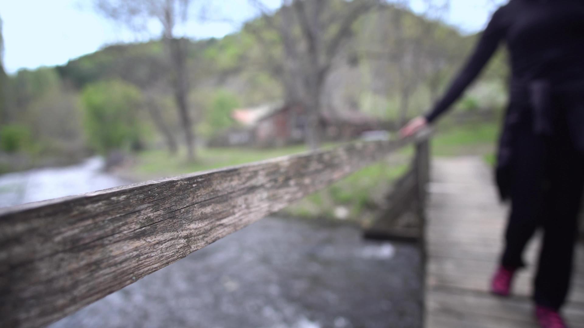 双脚靠在桥上的木桩上仰望河水下向下看视频的预览图