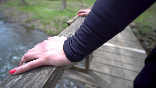 双脚靠在桥上的木桩上仰望河水下向下看视频的预览图