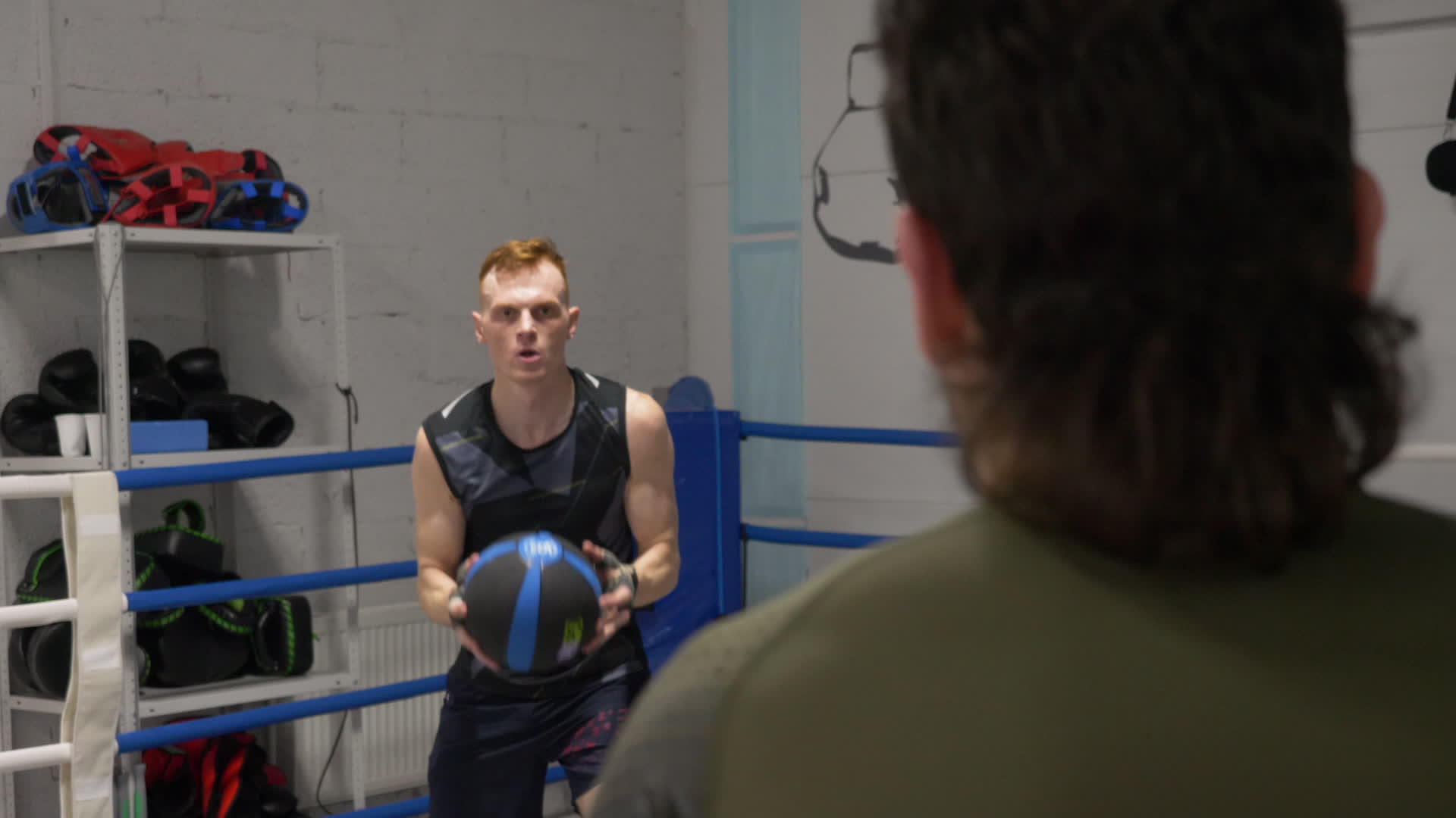 运动员在拳击俱乐部的拳击台上训练扔药球的拳击手视频的预览图
