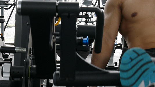 年轻人在健身中心用举重机锻炼男运动员在健身房锻炼视频的预览图
