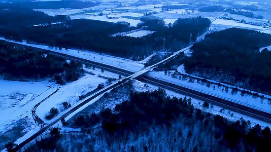 寒冷的沥青国家开阔的道路穿过冬天的雪地和日落或日出视频的预览图