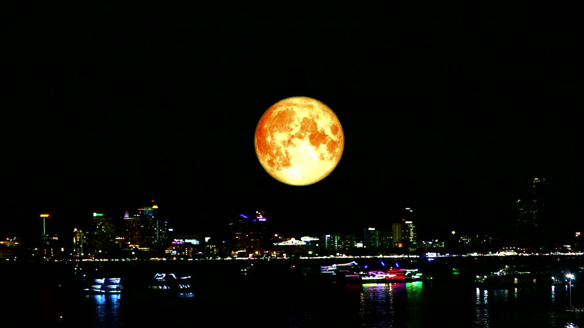 满月的鲜血笼罩着夜晚的城市和海上的船只视频的预览图