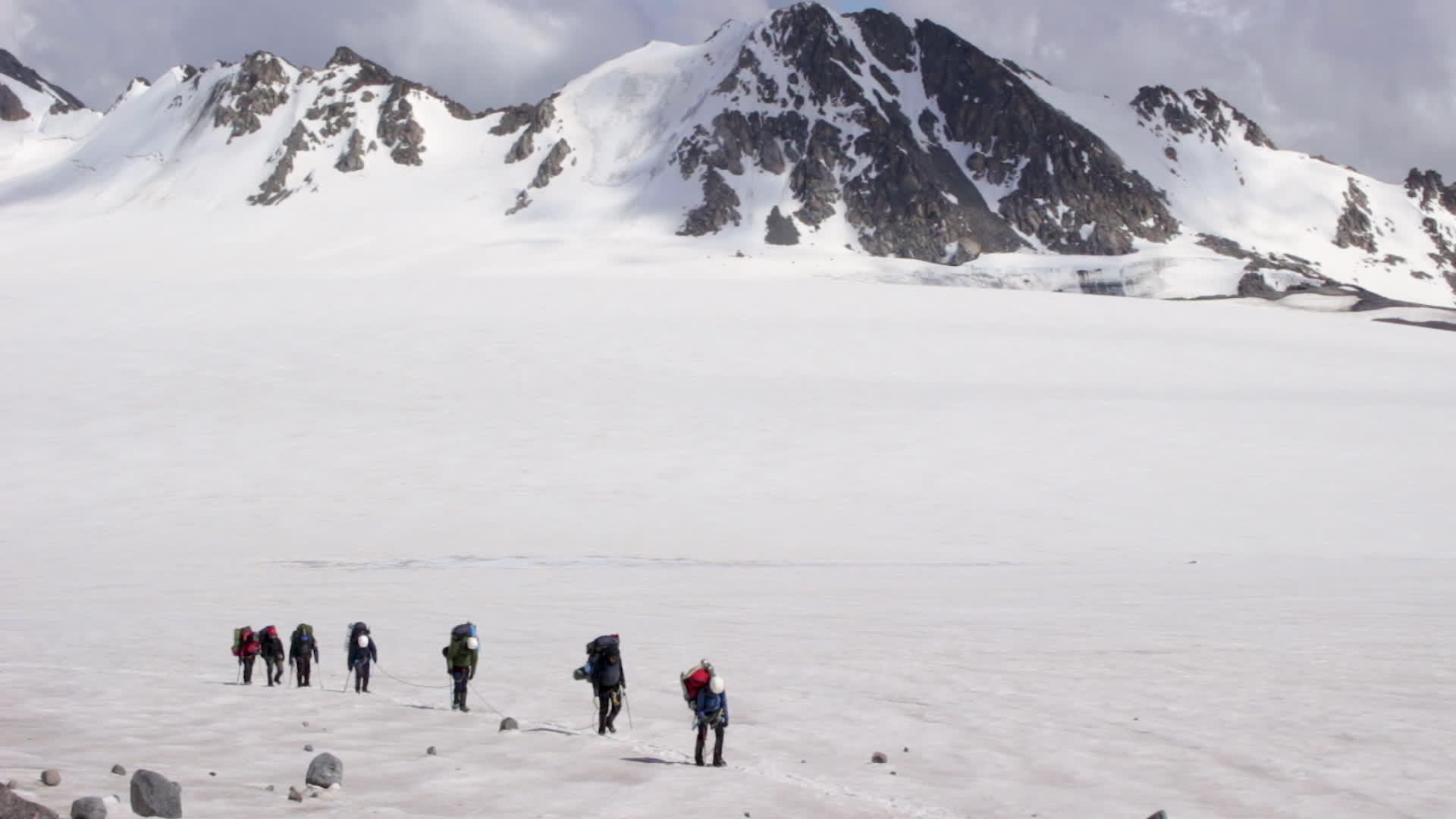 一群登山者背着背包用头盔、抽筋绳和冰斧在冰川里抽筋视频的预览图