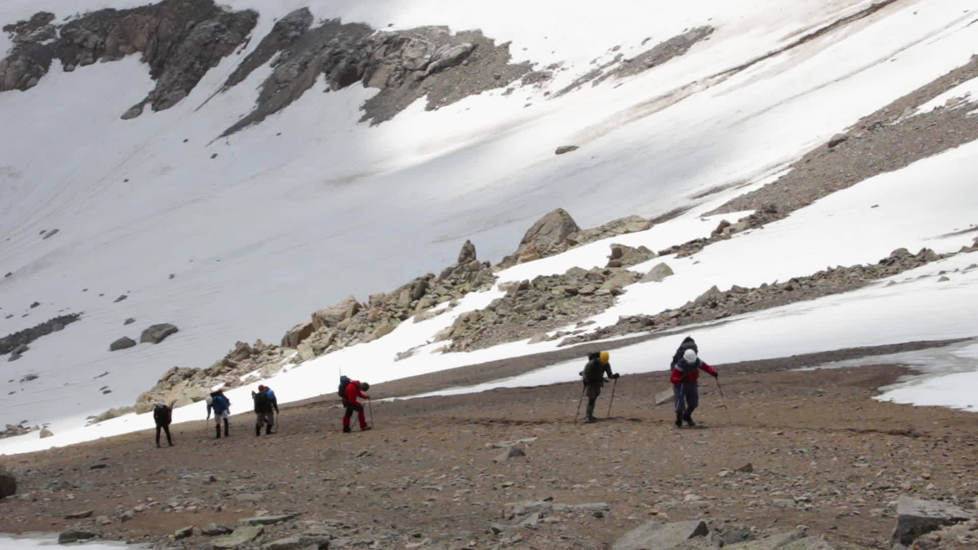 一群疲惫的徒步旅行者正在山上用徒步旅行杆和头盔山视频的预览图