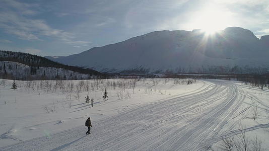 人们在阳光明媚的冬天在山上徒步旅行 无人机正在绕道视频的预览图