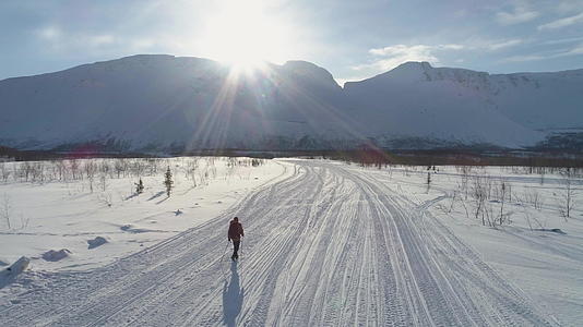孤独的人在阳光明媚的冬天在山上徒步旅行视频的预览图