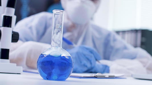 科学家在蓝色液体中加入试剂的手持胶片视频的预览图