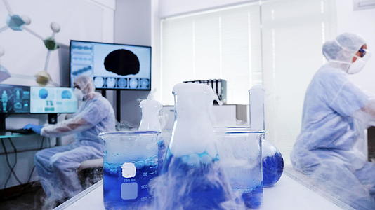 从手推车中提取蓝烟液体的覆盖设备中的科学家视频的预览图