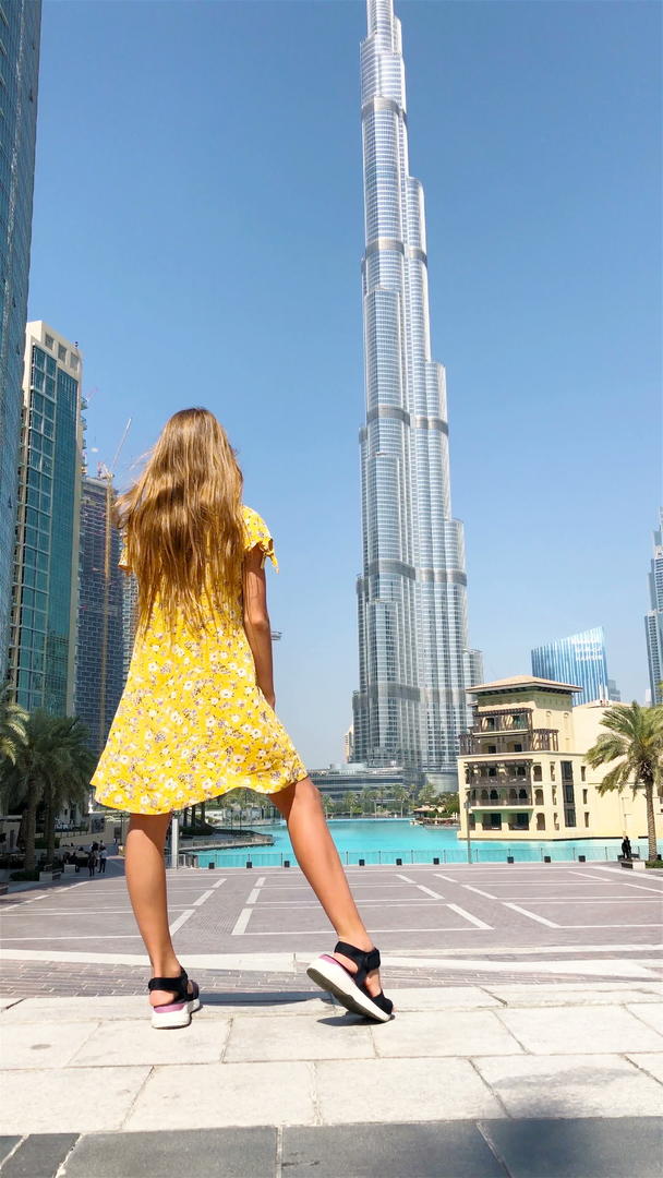 在杜拜散步的背景中快乐的女孩有摩天大楼视频的预览图
