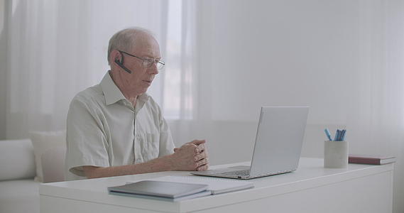 老年退休男子正在通过网络咨询专家和计算专家视频的预览图