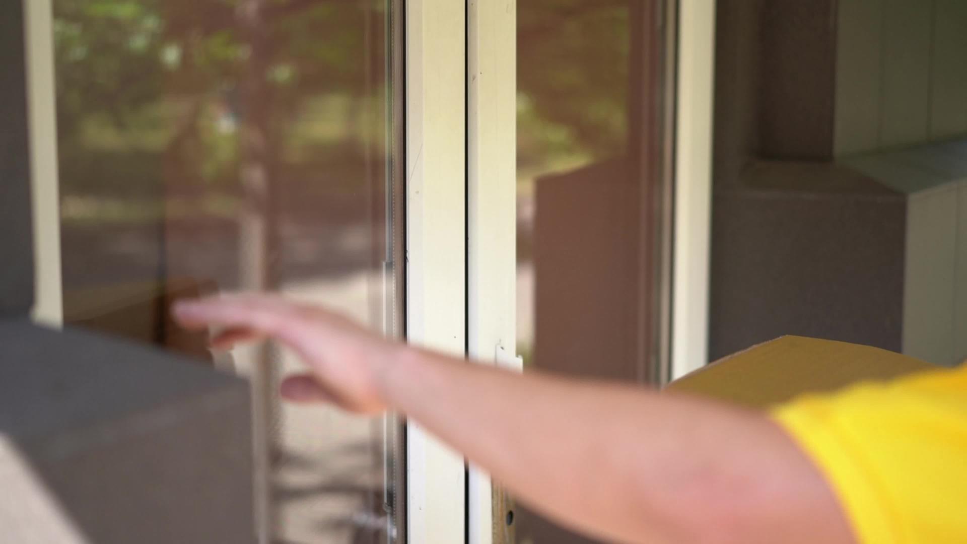 穿着黄色制服的快递员把披萨盒给了门口的女人视频的预览图
