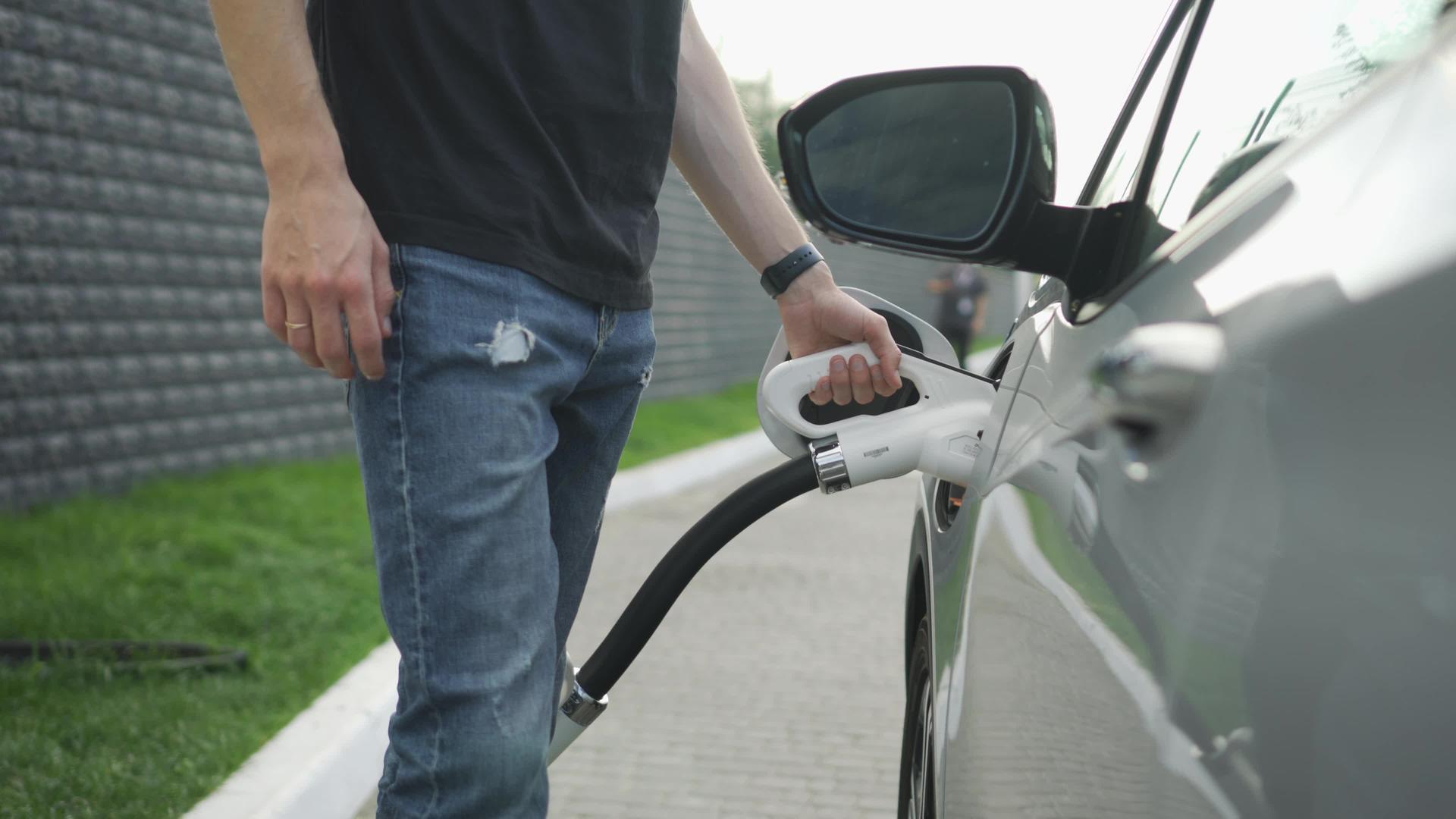 白人男子充电电动汽车车辆和快速直流充电电子移动站视频的预览图