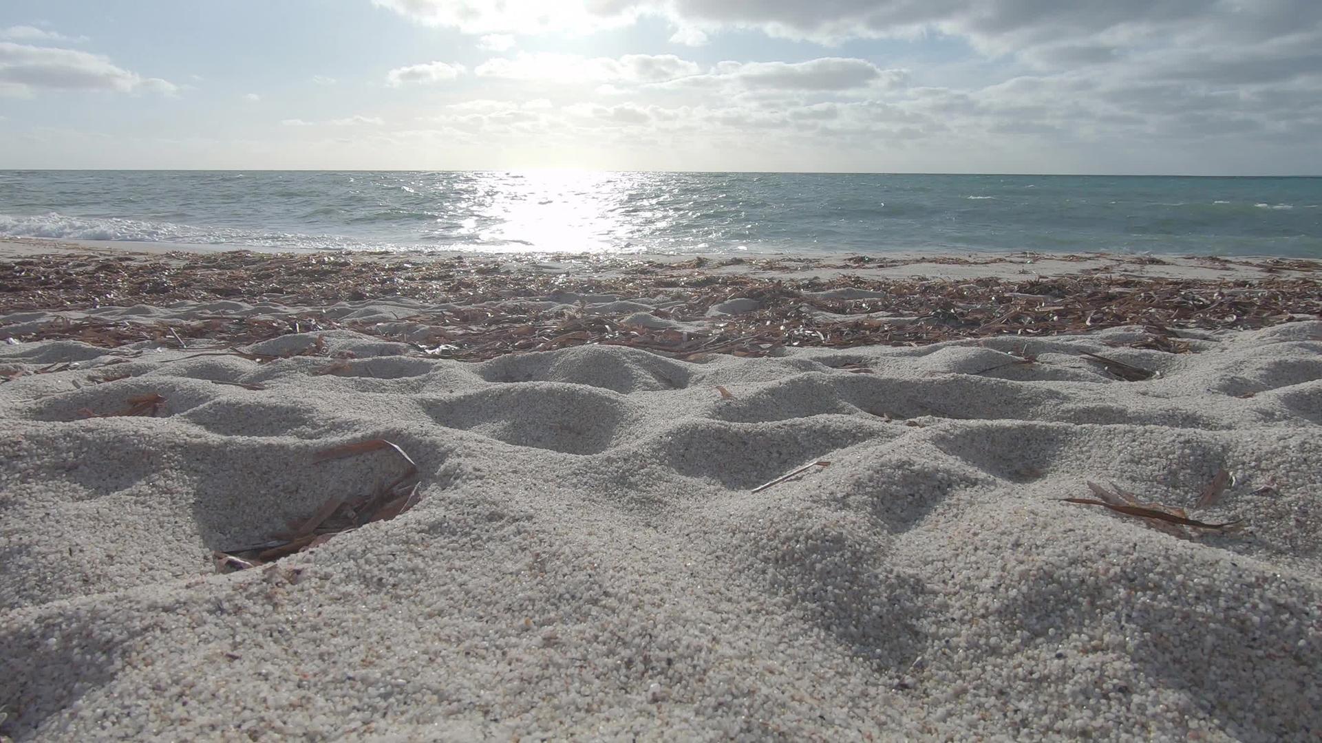 白石英砂粒的反射角度与海浪和背景中的云天空相似视频的预览图
