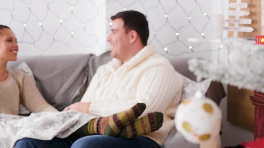 一对夫妇坐在圣诞礼堂的房间里坐在沙发上视频的预览图