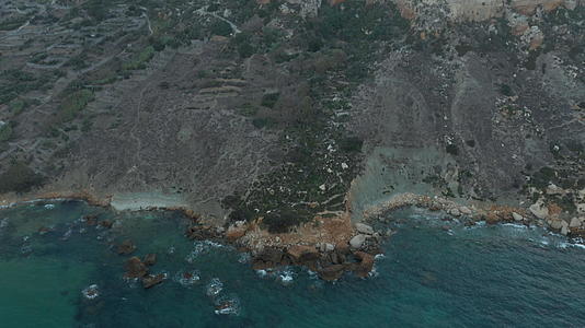 地中海岛屿美丽的海岸线蓝色海浪撞击岩石鸟眼在空中倾斜视频的预览图