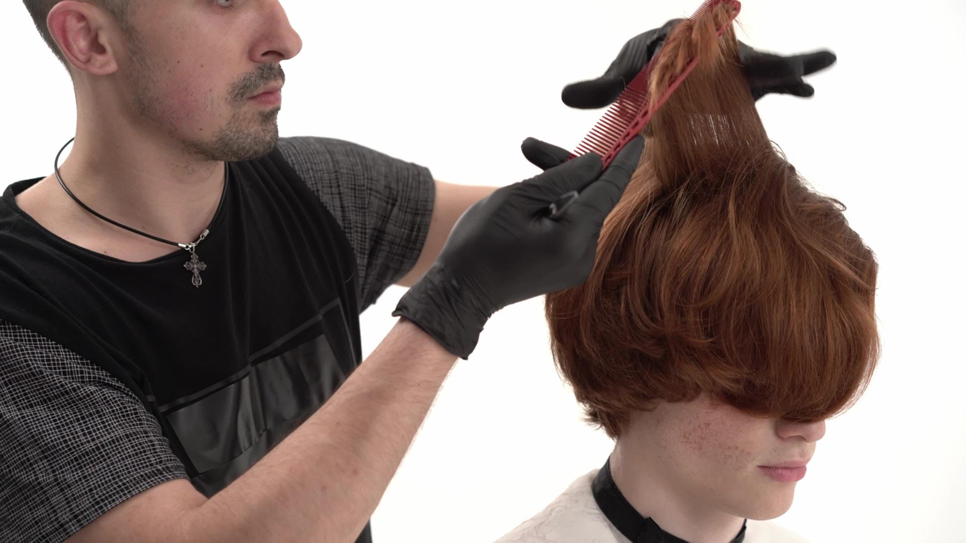 理发师给他的顾客理发用姜发梳子和剪刀视频的预览图