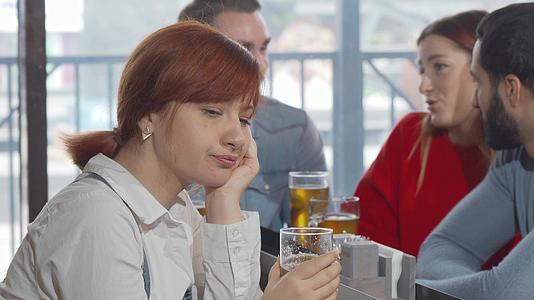 悲伤的女人在酒吧喝啤酒视频的预览图