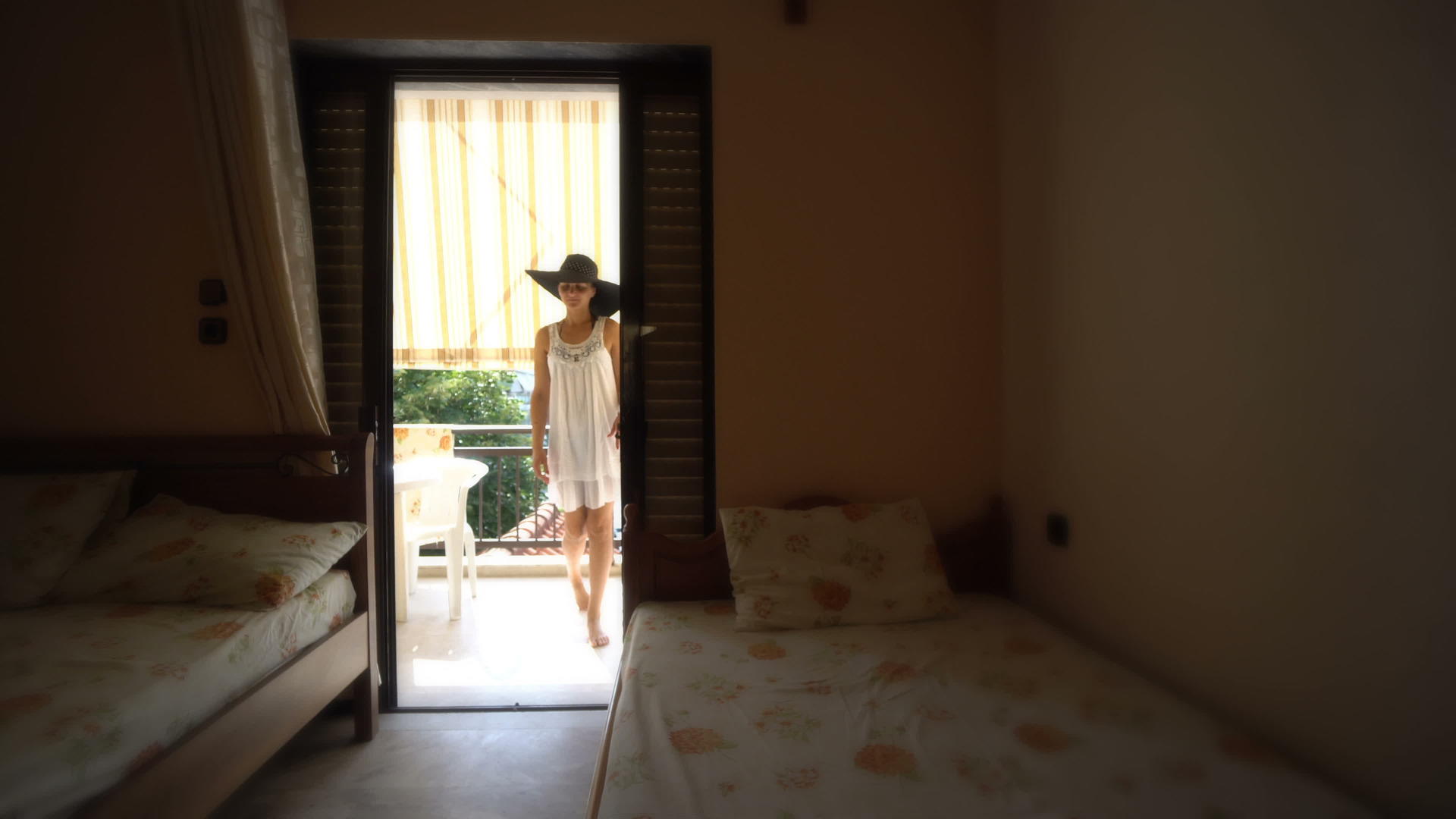 穿着白色夏装的年轻女子在地中海看日落时站在酒店里视频的预览图