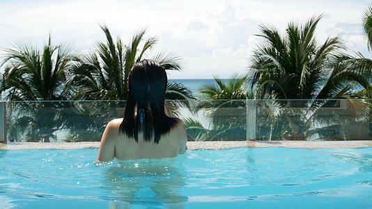 亚洲榈树热带海滩的背景下亚洲女性跳出游泳池底部视频的预览图