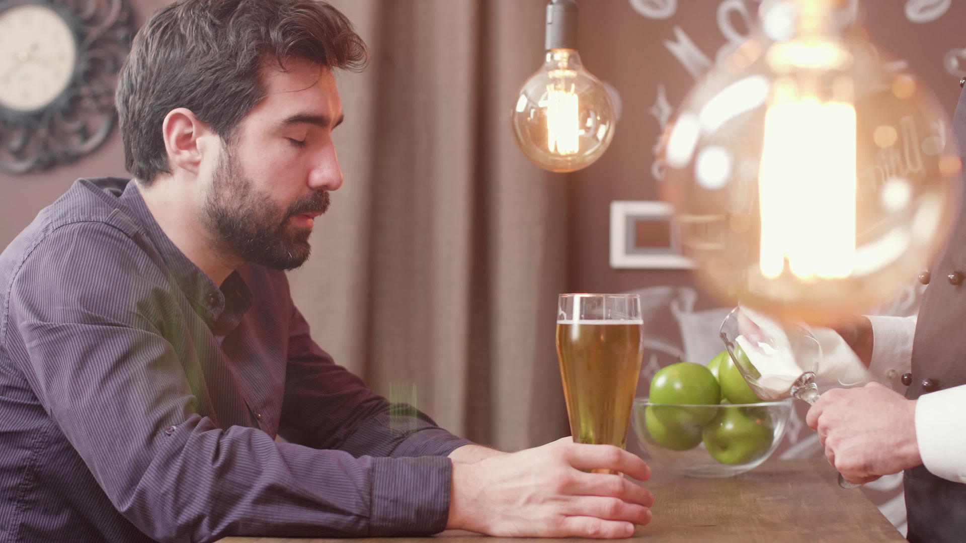男人在酒吧柜台和酒保聊天时喝啤酒视频的预览图