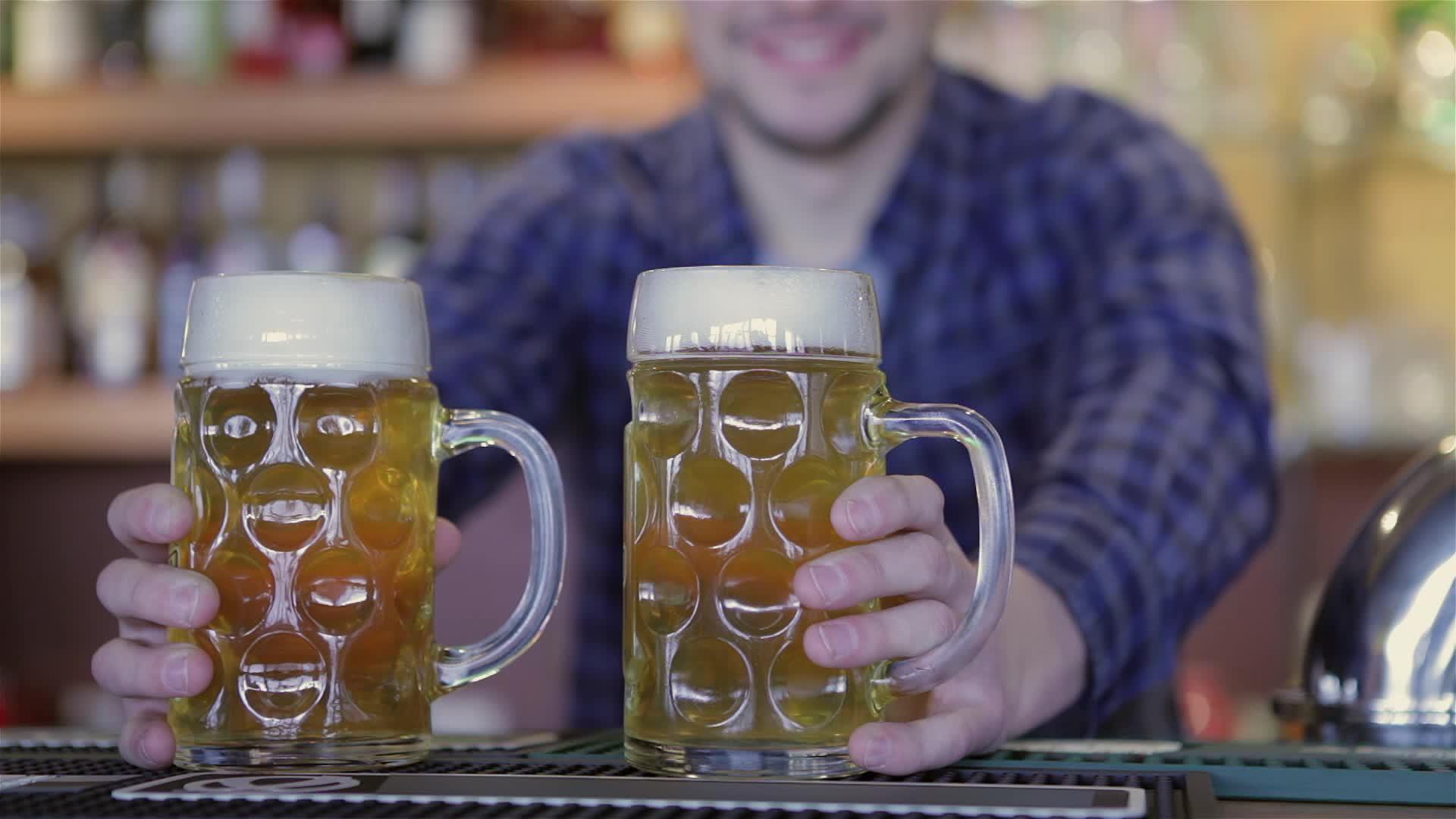酒保拿着啤酒杯和微笑视频的预览图
