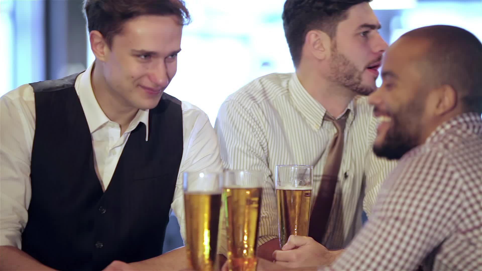 男人手里拿着一杯啤酒坐在酒吧里视频的预览图